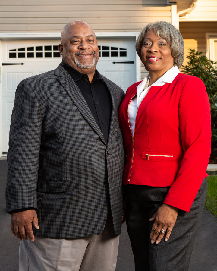 Linda and Charles in front of their home.